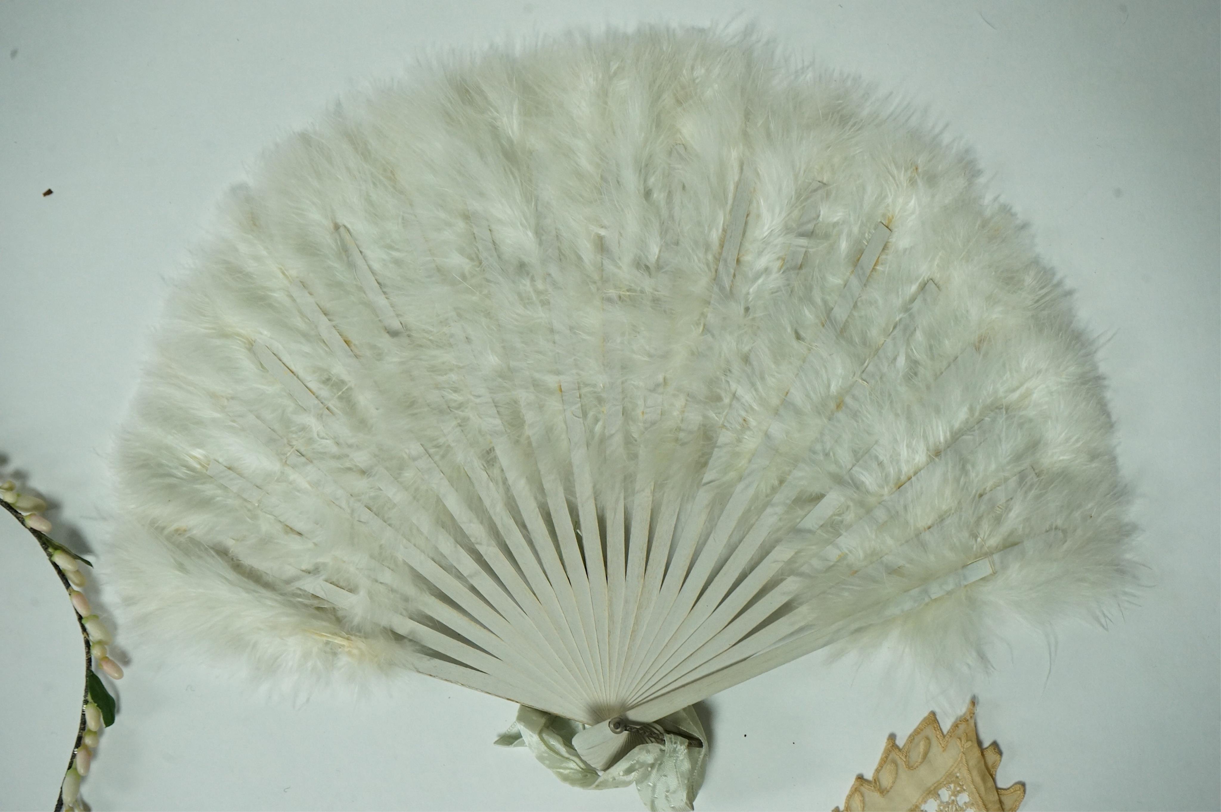 A 1920’s wax wedding headdress, a white feather fan, a bone brise and an earlier long lawn embroidered and lace worked stole., Stole 194cm long. Condition - headdress and fan good, stole has moth holes in places but can